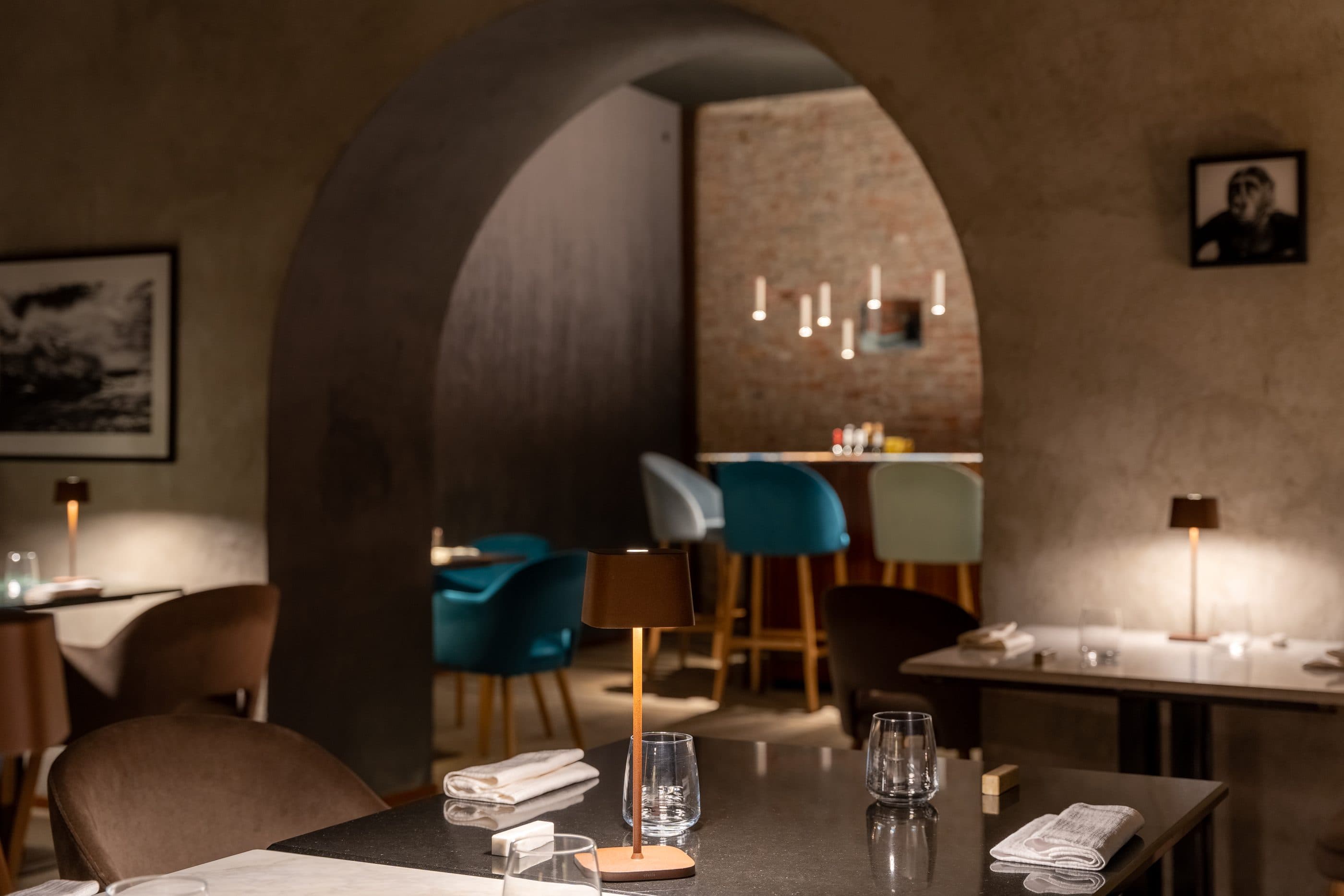 L'arco in pietra della sala principale, con il bancone dei vini illuminato che si intravede dietro