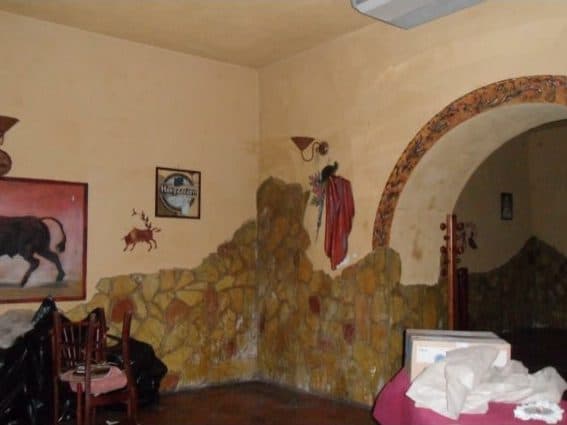 La sala del Flamenco prima dei lavori: finte pietre alle pareti, un murale con il toro, e l'arco già al suo posto